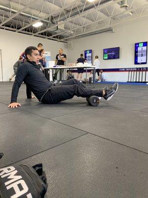 Dr Lopez teaching how to properly use the Hyperice hyper foam roller at F45 training gym.