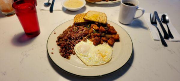 Corned beef hash and eggs with home fries.