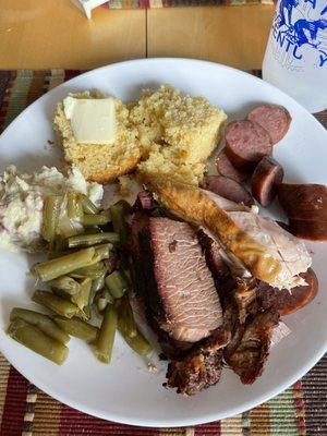 Portions of the Family Pack Special (brisket, sausage, chicken with sides of potato salad, green beans, and cornbread) $42!