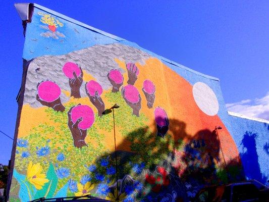 Colorful 'apple' mural bordering garden