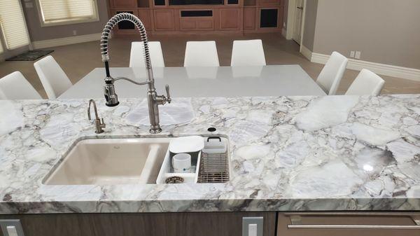 A beautiful Horizon Gray Marble and Quartz Kitchen Island in a remodeled custom home. Undermount sink.