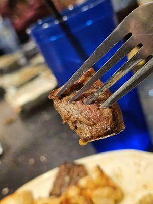 A piece of the Filet Mignon on a fork.