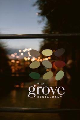 The grove Restaurant logo on outside of door entrance.