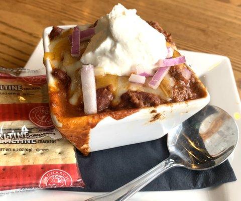 Chili loaded with cheese, sour cream and onions.