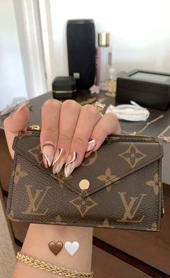 Long almond acrylic nails with a brown line design.