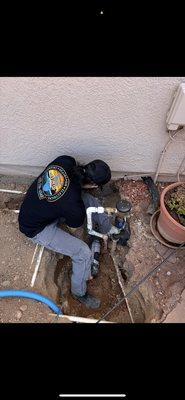 Boring through a foundation to run a new water main into the crawl space.