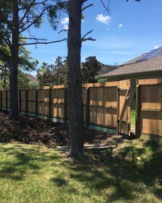 4x6 posts, 6' western red cedar pickets, 2x8 backer board to prevent erosion.