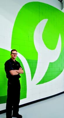 Owner John Cleveland with the shop mural