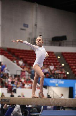 Competitive Gymnast showing her skills on the bar.