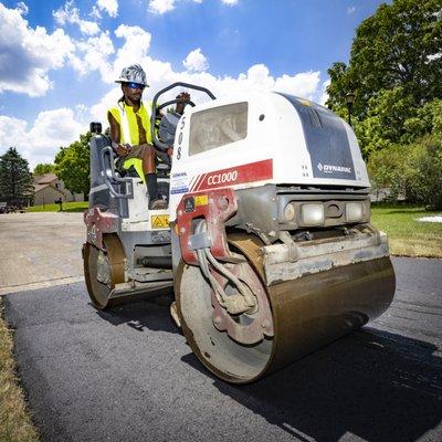 Roller man finishing an asphalt driveway