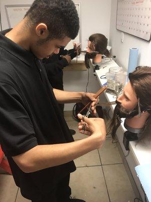 Beginner Barber Students learning how to use shears.