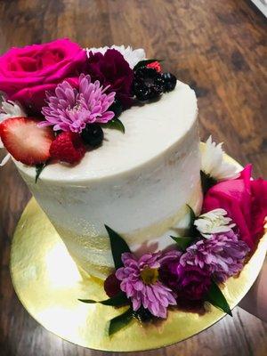 Vanilla Iilikoi cake with semi-naked frosting and fresh fruit and flower details