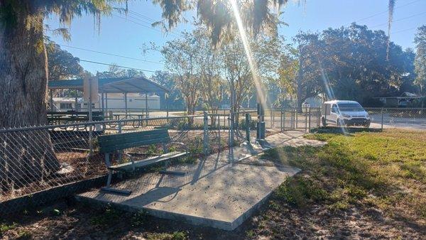 Double gated entry area, poop bag dispenser and trash can, water spigot and bench to sit upon