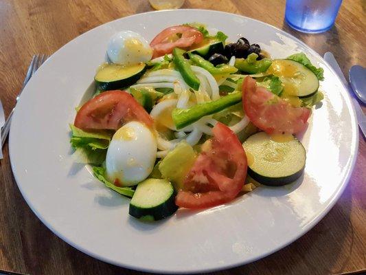 Big salad with green pepper, eggs, tomato, cucumber, onion and black olives