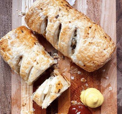 Baked sausage roll with ketchup and mustard