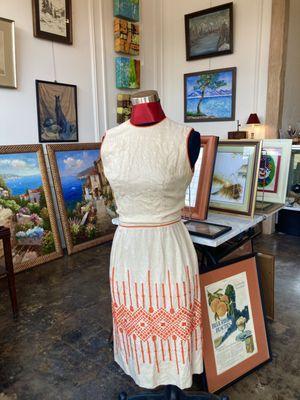 Mannequin is wearing a vintage, handmade linen dress with wool cross stitching. Lots of oil paintings in the background