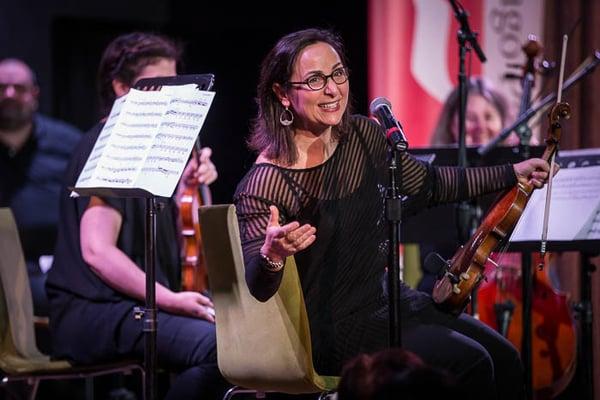 Violinist Carmen Llop-Kassinger addresses the audience during a Chicago Philharmonic Chamber Players concert. Photo by Elliot Mandel.