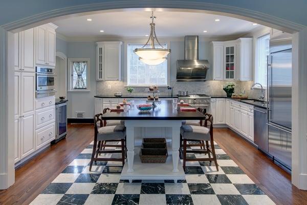 Archway into kitchen with white cabinets & custom island