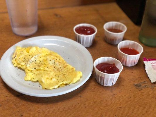 Scrambled eggs with ketchup and two hot sauces - one was a habanero hot sauce, the other was a Buffalo sauce