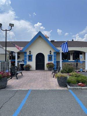 Exterior. Cute arched door and Greek colors. Also has outdoor seating under a tent