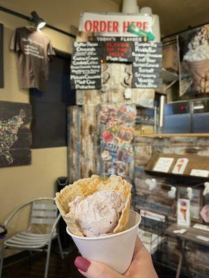 Single scoop Huckleberry Honey & Lavender in a waffle cone