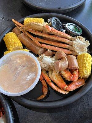 Dungeness and snow crab with corn on the cob and sausages