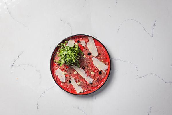 BEEF CARPACCIO
 Grass-fed Thinly Sliced Raw Beef, Worcestershire Aioli, Shaved Parmigiano, Arugula, Balsamic Glaze