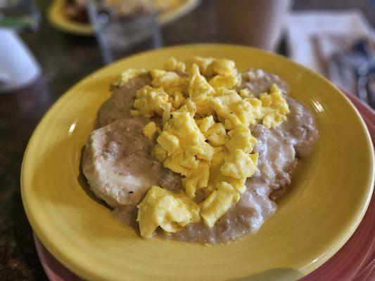 Sausage gravy over biscuits topped with scrambled eggs