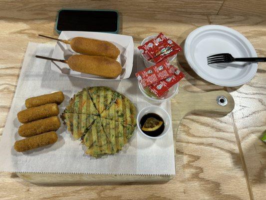 Corn dogs, mozzarella sticks, scallion pancakes with sides of fruit.