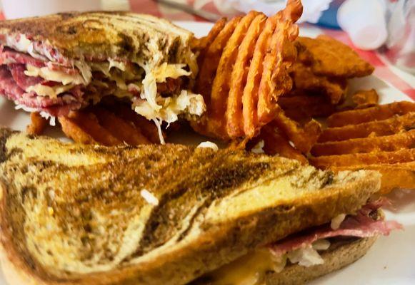 A classic, perfectly crafted Reuben Sandwich with crispy Waffle Cut Sweet Potato Fries. Clockers does it right.