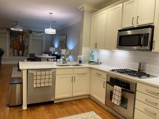 After installation of kitchen modifications (quartz countertop, subway tile backsplash, sink, and countertop remodel, redesign)