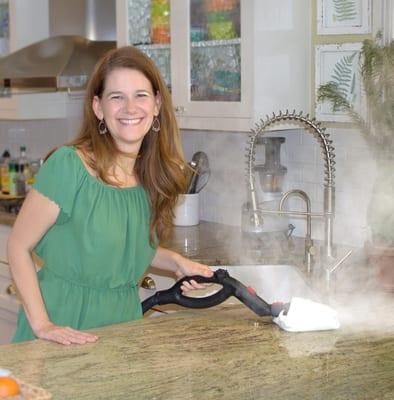 Diana, owner, steaming a countertop clean.  The steam, sanitizes, removes build and bacteria causing orders in one step.