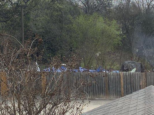 Homeless encampment behind hotel parking lot