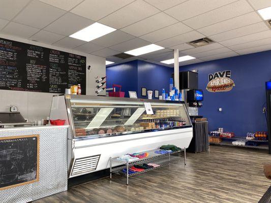 Deli counter with deli meats, cheeses, salads, and desserts.