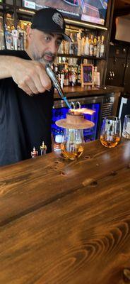 Bartender making my DELICIOUS SMOKED OLD FASHIONED