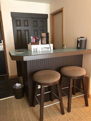 Kitchenette with mini refrigerator, microwave, and coffee maker.