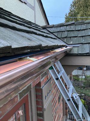 Copper gutters 5"K with brass hangers.