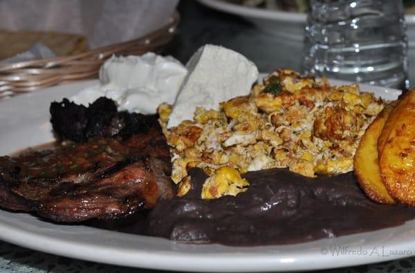 Carne Asada con salsa picante, huevos, frijoles, queso fresco, maduros y tortilla