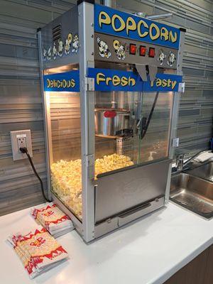 Complimentary self-serve popcorn in the customer service waiting area. The scoop sits way on top of the machine.