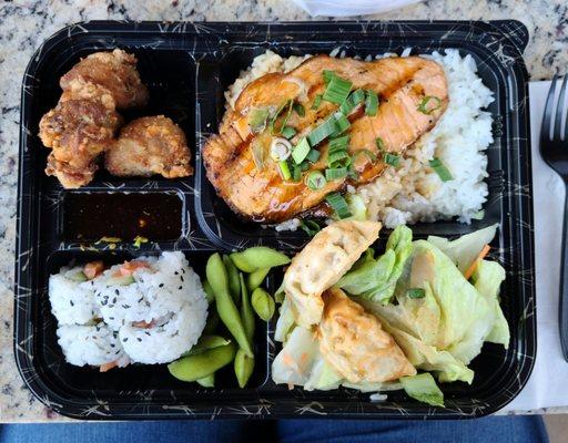 Bento Box: teriyaki salmon, and salmon roll. Includes: salad, edamame, potstickers, and sesame chicken.