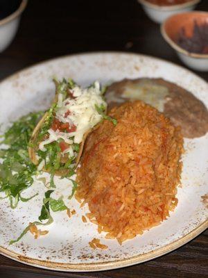 One taco plate with beans and rice.