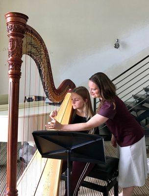 Demonstrating hand position at a harp lesson.