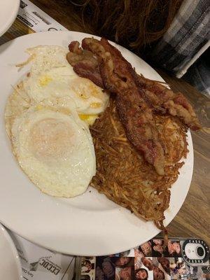 Three dippy eggs hash browns and bacon