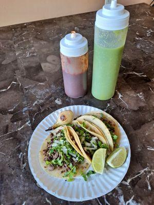 Beef tacos with lime and a charred onion, and bottled salsas.