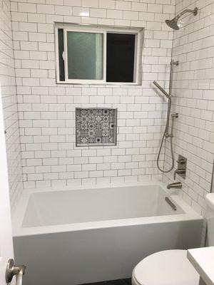 Beautiful subway tile with brush nickel finishes and an acrylic tub