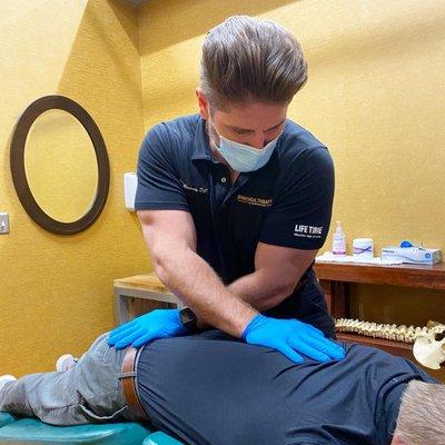 Dr John Maloney, DC - Our Chiropractor using the Flexion Distraction table to treat Low back pain and Mid back pain