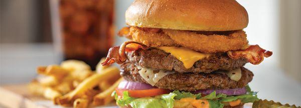 All-World Double Cheeseburger, American + Swiss cheese on 2 burgers with smoked bacon strips, onion rings, and Thousand Island dressing.