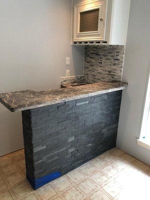 Rebuilt bar with custom granite,  black slate,  stack stone for backsplash.