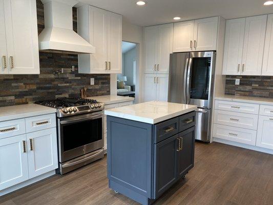 Maple Shaker painted White, Charcoal Navy Island on Castors, Honey Bronze fixtures, polished Porcelain countertops & rustic tile backsplash