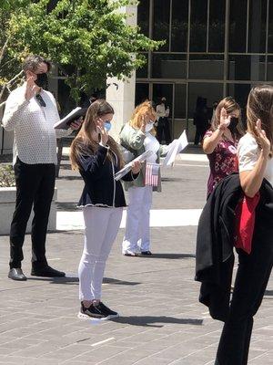 giving oath in small groups with distance outside in courtyard